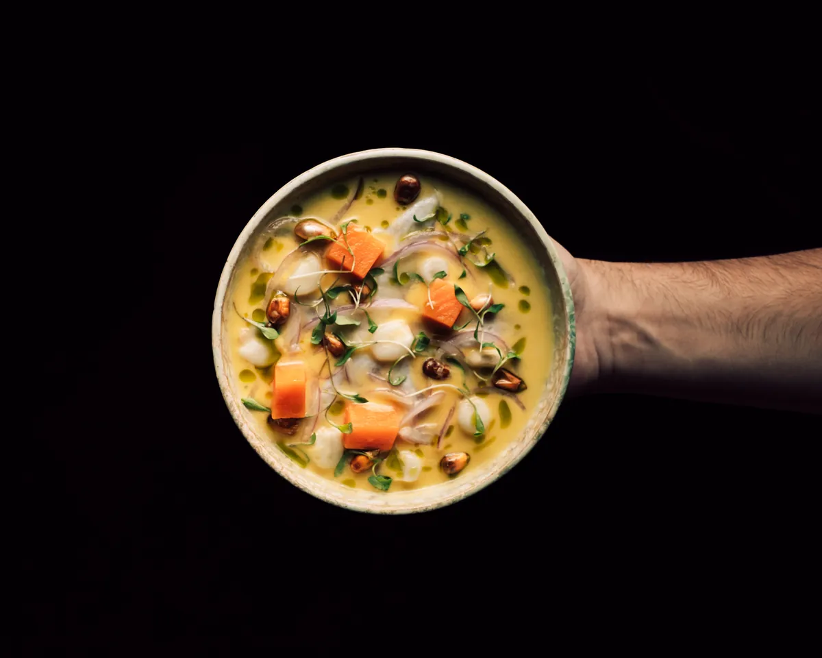 Ceviche servido en un cuenco sostenido en la mano