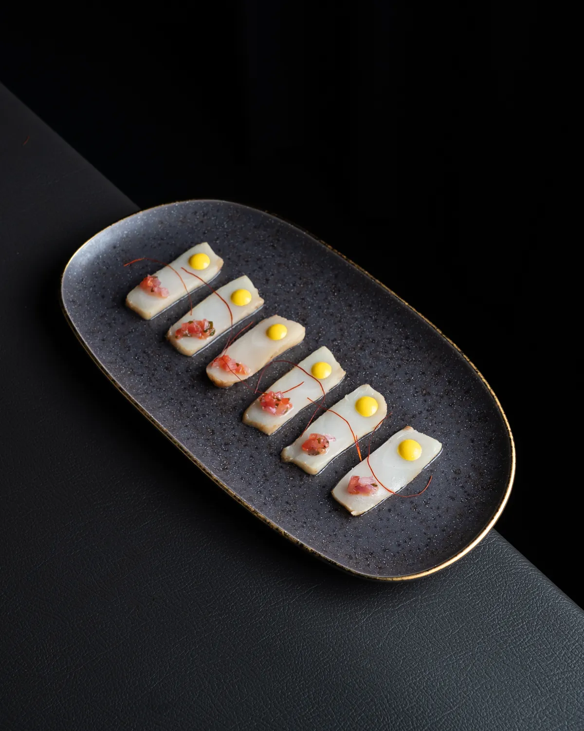 Plato de crudo de pescado sobre banco de cuero