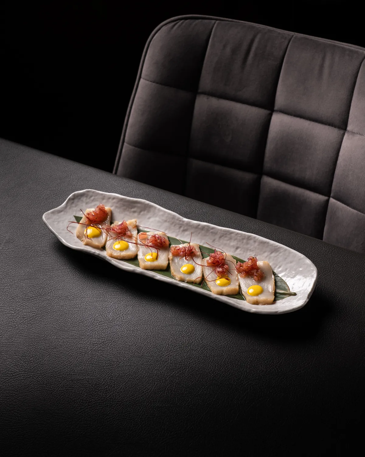 Plato de crudo de pescado servido en mesa de restaurante
