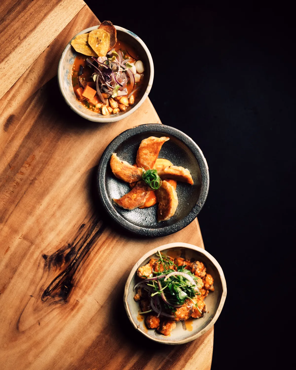 Tres platos de cocina de autor sobre mesa de madera