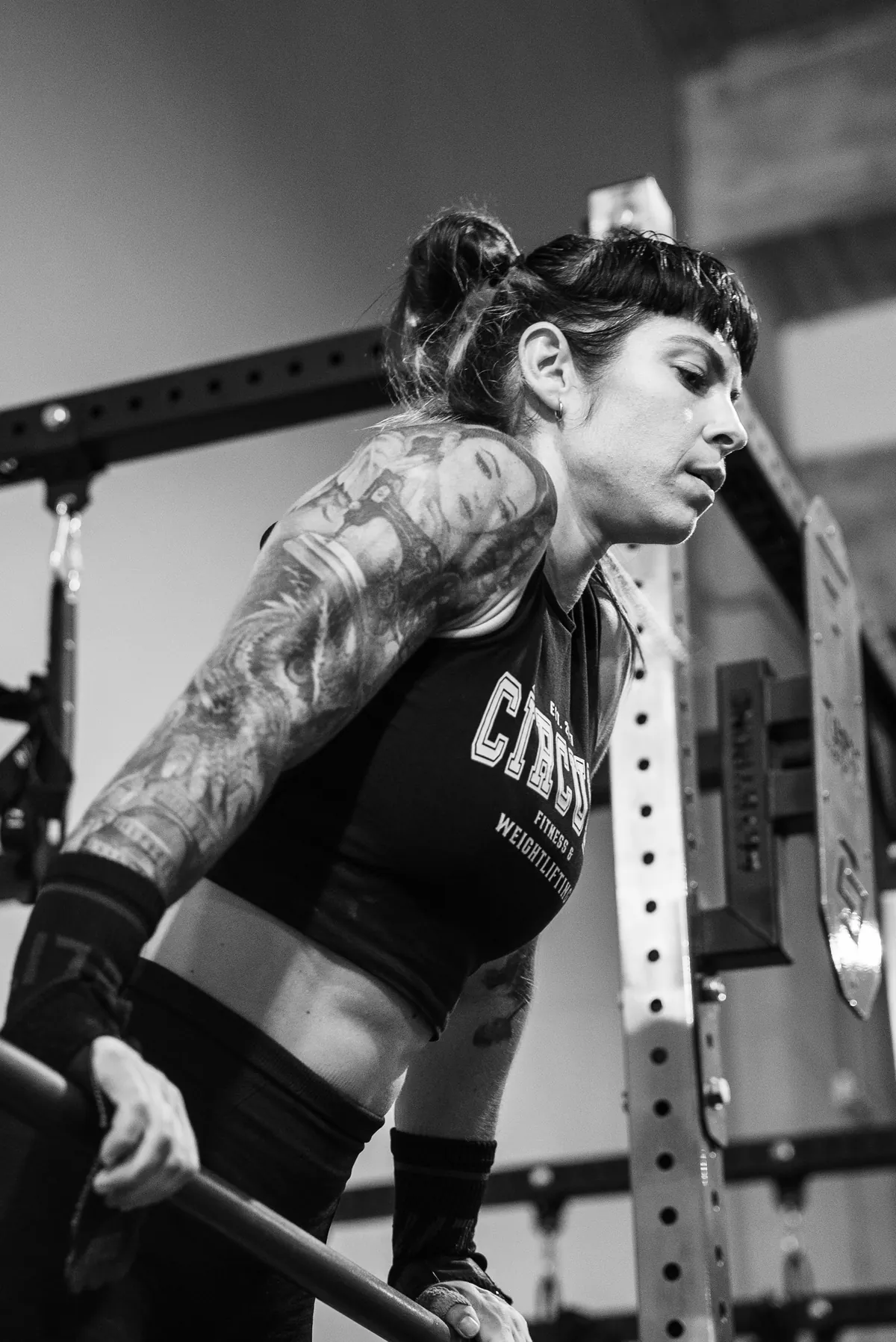 Atleta levantando una barra, brazo con tatuajes