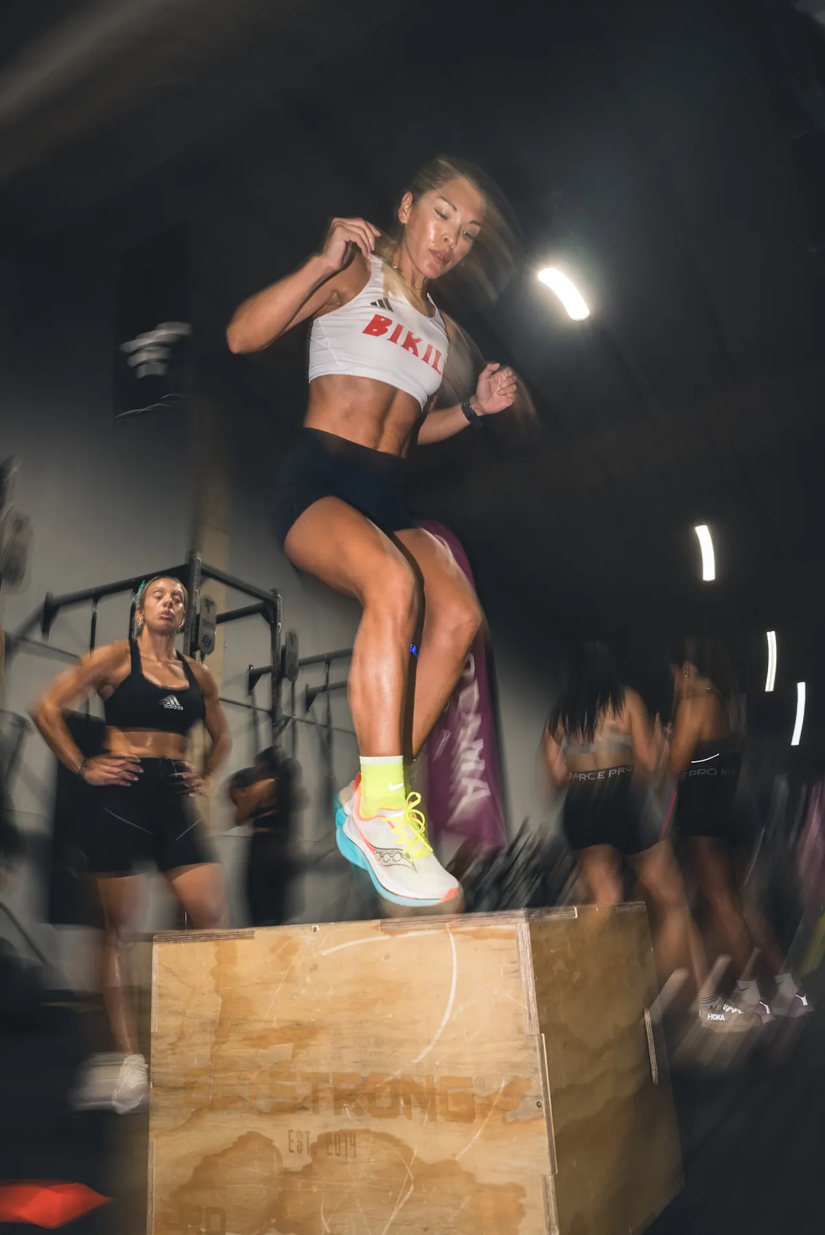 Atleta en el aire durante un box jump en competición